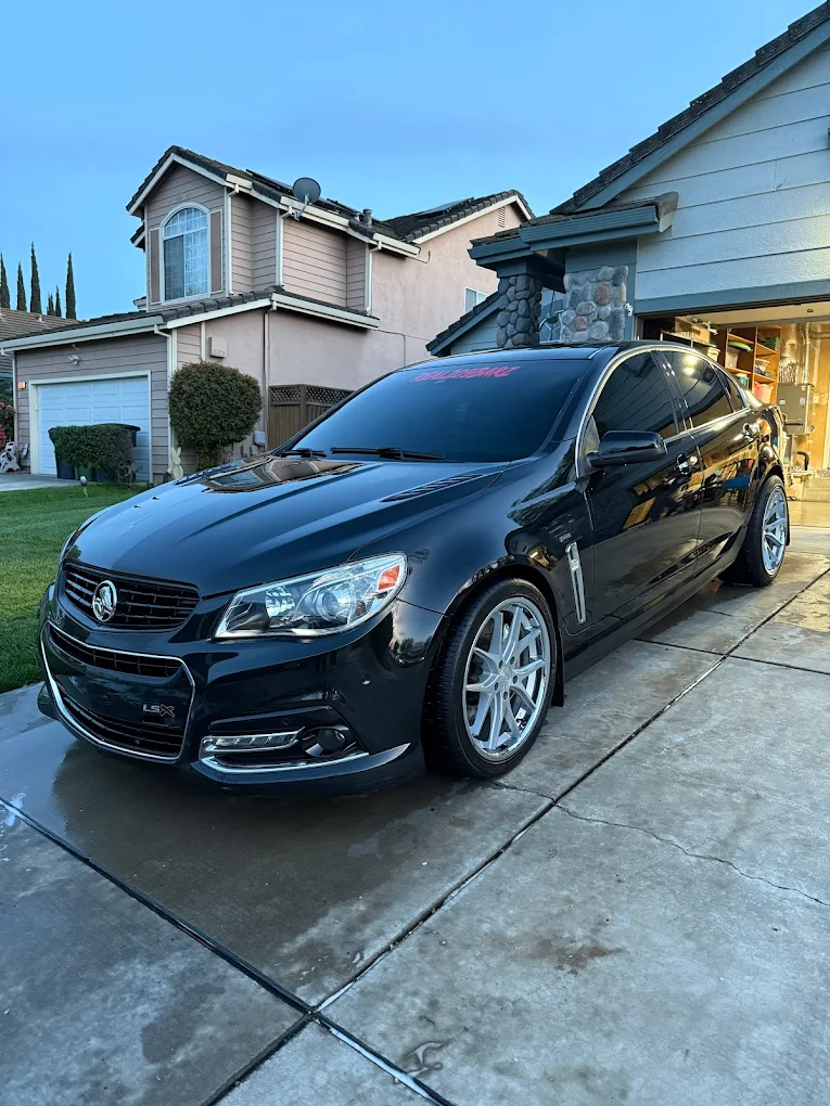 Freshly washed black sedan in a driveway